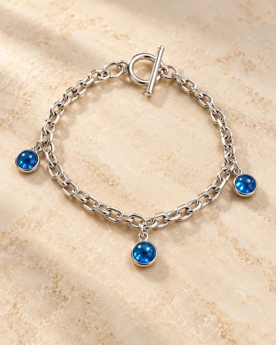 The same silver bracelet with three blue charms in a professional studio photograph
