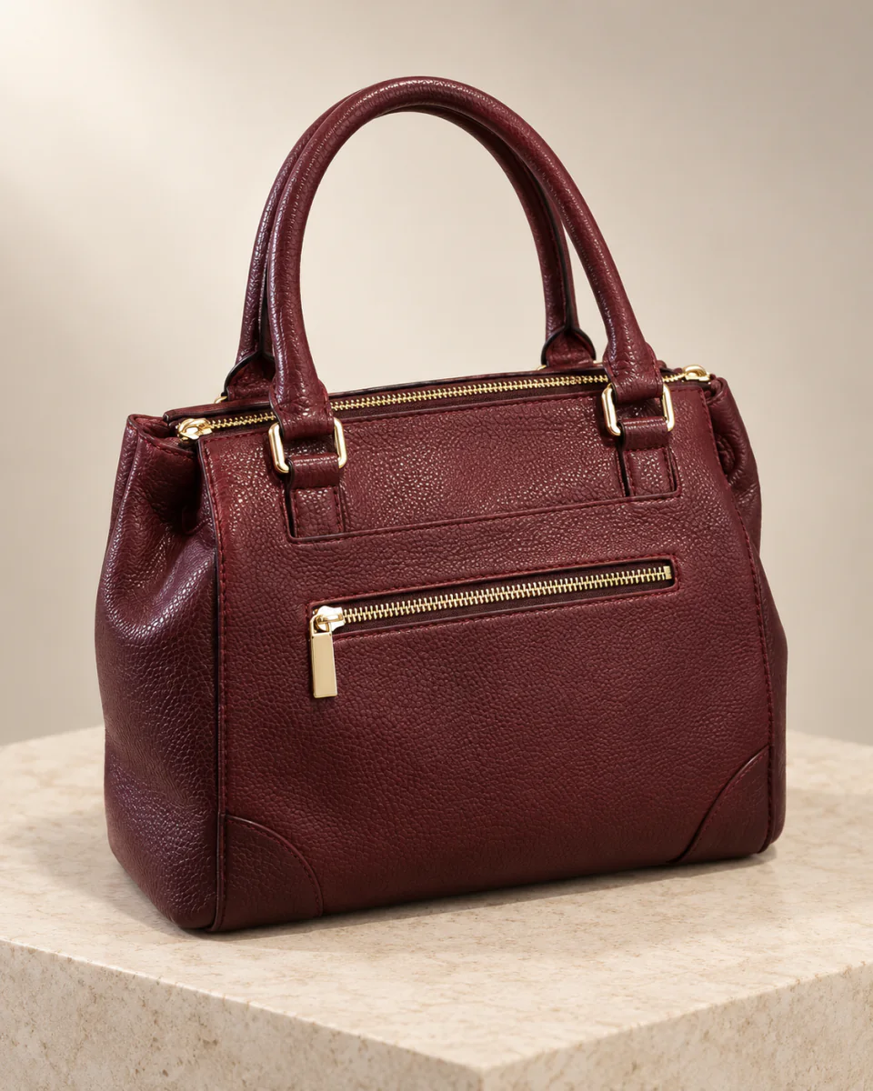The same burgundy top-handle handbag in a professional studio product photograph