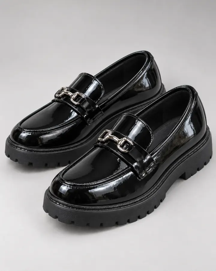 Black patent loafers in a polished studio product photo